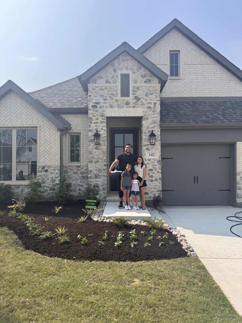 A family standing in front of their newly purchased home in Frisco
